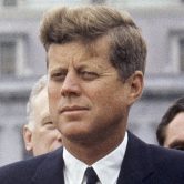 John F. Kennedy listens while Grand Duchess Charlotte speaks in Washington.