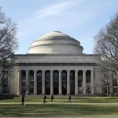 Students walk past the "Great Dome" atop Building 10 on the MIT campus.