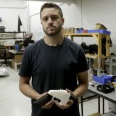 Cody Wilson of Defense Distributed holds a 3D-printed gun called the Liberator at his shop in Austin, Texas.