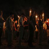 White nationalists carrying tiki torches walk through the University of Virginia campus at night.
