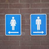 Gender signs point the way to restrooms.