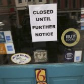 A closed sign is displayed on the door of a New Hampshire business