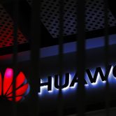 A logo of a Huawei retail shop is seen through a handrail inside a commercial office building in Beijing.