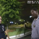 An Atlanta police officer speak to a man in a parking lot.