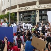Protestors demonstrate against police brutality outside a courthouse.
