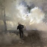 A protester in a fog of tear gas.