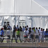 Children line up to enter a tent at a temporary immigrant shelter in Homestead, Fla.