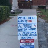 A sign on a sidewalk indicating a polling place.