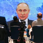 Vladimir Putin speaks via video call during a news conference.