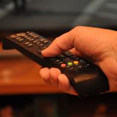 A person holds a remote control.