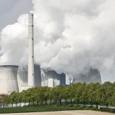 A coal-fired RWE power plant steams on a sunny day in Neurath, Germany.