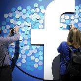 Attendees stick notes on a Facebook logo at F8, the Facebook's developer conference.
