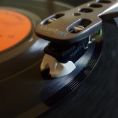 This photo shows the arm and needle of a record player.