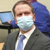 Derek Chauvin, wearing a suit and face mask, listens to the verdicts at his trial in Minnesota.