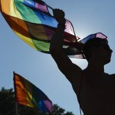 Participants wave flags and dance during a Gay Pride parade in Spain.
