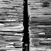 Two stacks of documents pile high