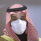 Mohammed bin Salman wears a face mask as he attends a ceremony.