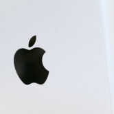 The Apple logo is displayed on a Mac Pro desktop computer