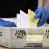 An election worker thumbs through ballots.