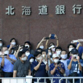 Spectators wearing masks watch the women's marathon at the 2020 Summer Olympics.
