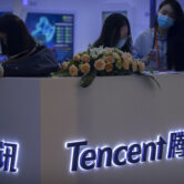 People stand at a Tencent booth at a fair in Beijing, China.