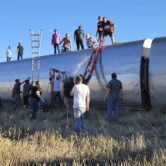 People help at the scene of a train derailment