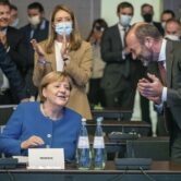 German Chancellor Angela Merkel receives applause at a meeting.