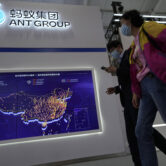 Visitors to a trade fair pass by the Ant Group booth in Beijing, China, Monday, Sept. 6, 2021.