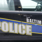 A Baltimore police cruiser is seen outside of a building as officers check on a call.
