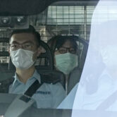 Chow Han Tung is escorted by police in a van to a court in Hong Kong.