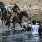 U.S. Customs and Border Protection mounted officers attempt to contain migrants.
