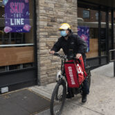 A delivery man bikes with a food bag from Grubhub in New York.