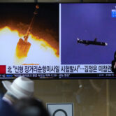 People watch a news program reporting about North Korea's long-range cruise missiles tests.