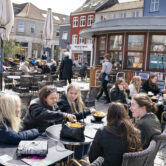 People sit outside a restaurant for outdoor service in Roskilde, Denmark, as cafes and bars reopened.