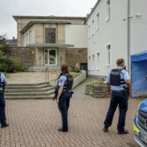 Police officers stand in front of the Jewish Community building in Hagen, Germany.