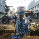 A woman sells food on a street in Conakry, Guinea.