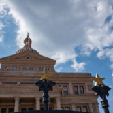 View of the North side of the Texas Capitol through an iron gate
