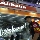 A security guard passes by the Alibaba booth at a trade show in Beijing, China.