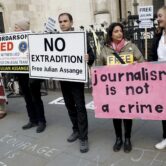 Julian Assange supporters hold banners outside a courthouse in London