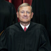 Supreme Court Chief Justice John Roberts sits during a group photo.