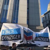Outside court, a protest says "Free Donziger" and the word "Lies" drips like oil from the Chevron logo