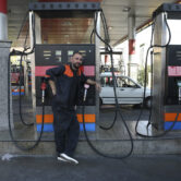 A worker leans against a gasoline pump in Tehran, Iran.