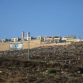An Israeli flag is painted on the surrounding wall of the West Bank Jewish settlement of Migdalim.