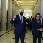 President Joe Biden gives a thumbs up as he walks with House Speaker Nancy Pelosi on Capitol Hill.