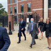 Former SCANA CEO Kevin Marsh walks out of a courtroom with his lawyers.