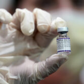 A healthcare worker holds a vial of the Pfizer Covid-19 vaccine.