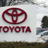 The company logo adorns a sign outside a Toyota dealership.