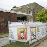 A man runs by fencing displaying artwork outside the Tree of Life synagogue in Pittsburgh.