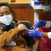 A 9-year-old boy receives a Covid-19 vaccination in New Jersey.