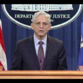 Attorney General Merrick Garland stands at a podium to announce charges against a suspected ransomware hacker during a press conference on Nov. 8, 2021.